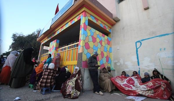 أمهات وآباء ينامون أمام المدرسة لتسجيل أبنائهم